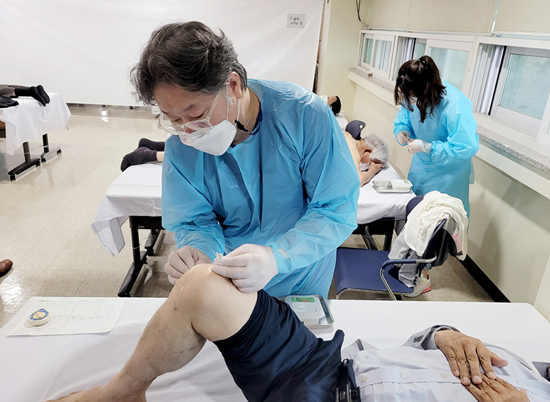 수원자생한방병원 윤문식 병원장이 무릎이 불편한 어르신에게 침치료를 시행하고 있다. | 자생한방병원·자생의료재단