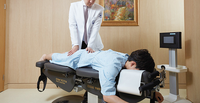 자생한방병원 이진호 병원장이 허리디스크 환자에게 추나요법을 하고 있다. | 자생한방병원·자생의료재단