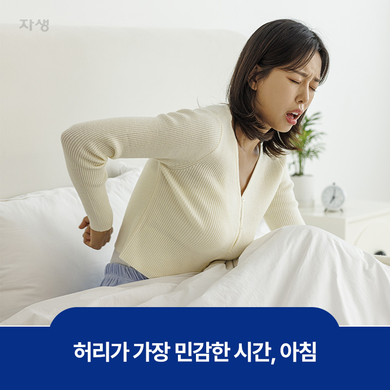 허리가 가장 민감한 시간인 아침에 허리를 두드리며 통증을 호소하는 이미지