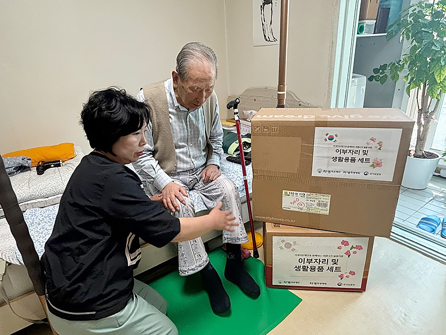 자생의료재단 관계자가 독립유공자 어르신 가정을 방문해 여름 침구류 세트와 생필품을 전달하고 있다. | 자생한방병원・자생의료재단