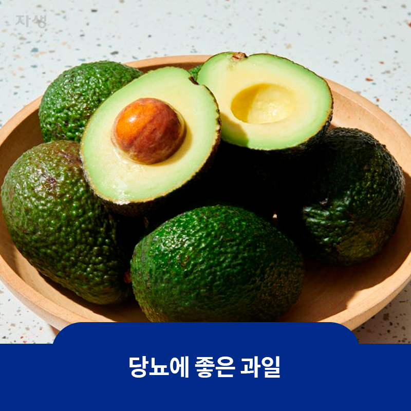 당뇨에 좋은 과일인 초록색의 아보카도 여러 개가 나무 그릇에 담겨 있고 1개는 반이 잘려 놓여있는 이미지