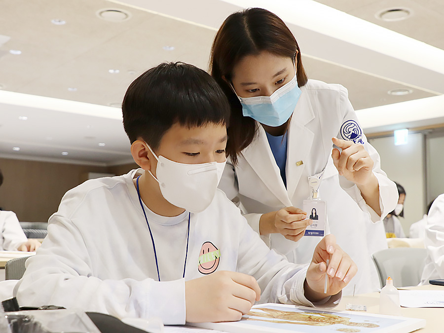 청담중학교 학생이 자생한방병원 의료진과 함께 침치료 실습을 하고 있다. | 자생한방병원・자생의료재단