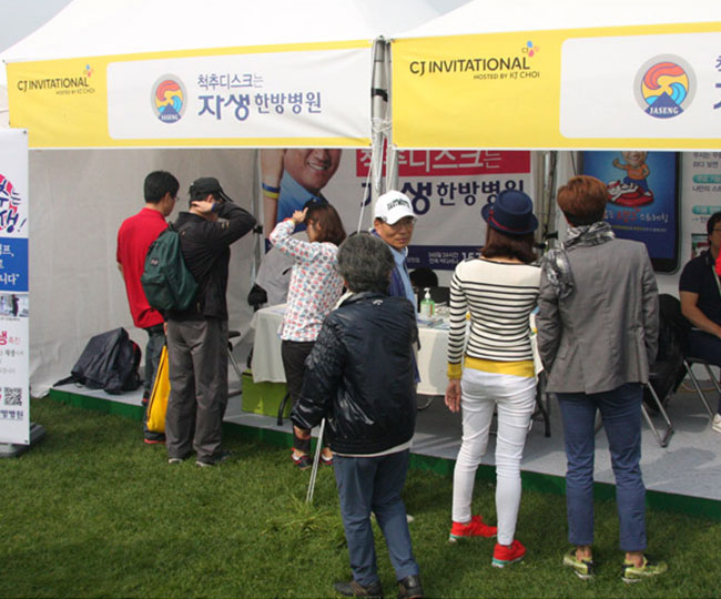 CJ인비테이셔널 의료 후원이 펼쳐지는 모습. 현수막 앞에서 줄을서서 순서를 기다리고 있는 시민들.