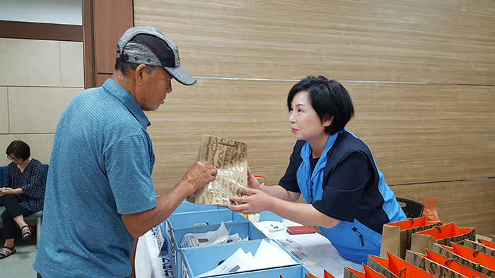 자생의료재단 사회공헌실 김동희 실장이 의료봉사 현장에서 한방파스를 나눠주고 있다.