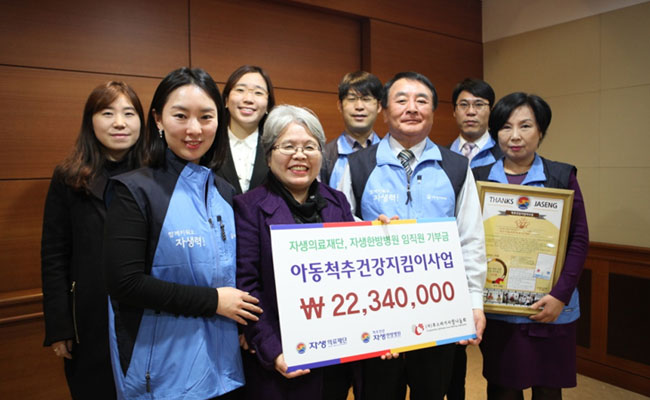 아동척추건강지킴이사업 기금 전달 기념 단체 촬영. 22340000원의 기금을 전달한 모습.